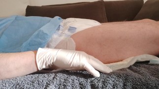 Urinating in a diaper with an inserted catheter after filling the bladder, relaxing...
