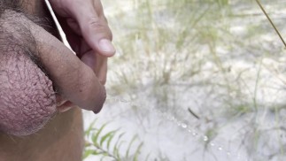 Pissing on a public beach with big balls