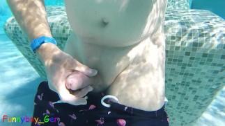 Gay guy cheekily jerks off his fat cock in a public thermal pool. Hot underwater fun.