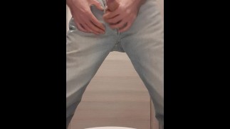 young skinny guy in blue jeans and black t-shirt jerks off and cums hard in public toilet
